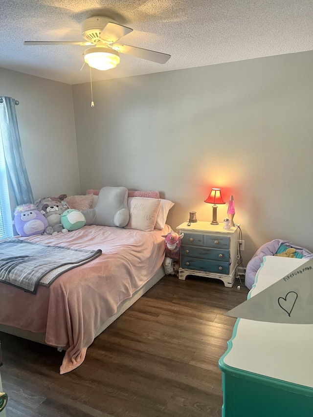 bedroom featuring ceiling fan, dark wood-type flooring, and a textured ceiling