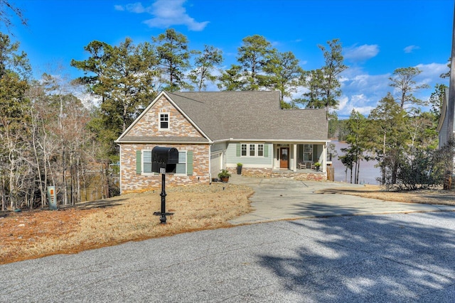 view of front of property featuring a garage, stone siding, and concrete driveway