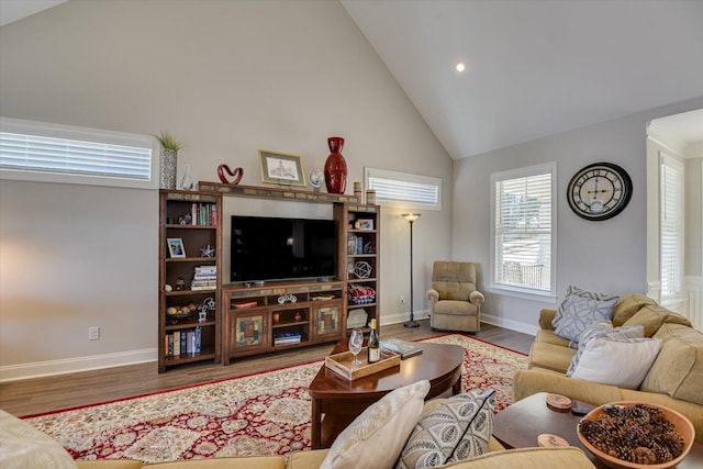 living area with high vaulted ceiling, wood finished floors, and baseboards