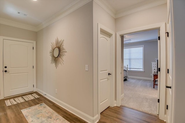 entrance foyer with baseboards, dark wood finished floors, visible vents, and crown molding