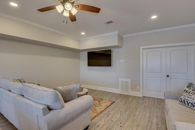 living room featuring crown molding, visible vents, and wood finished floors