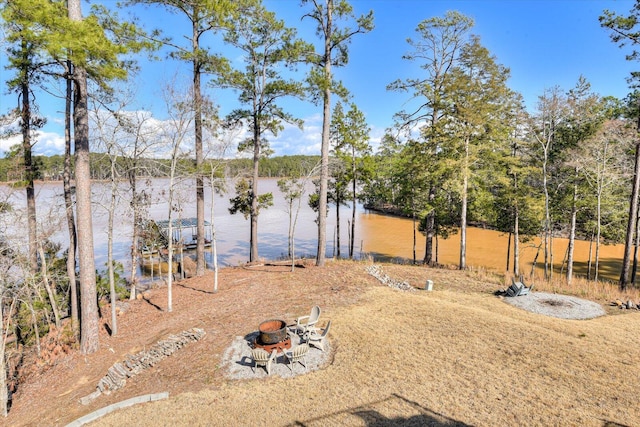 view of yard featuring a water view and an outdoor fire pit