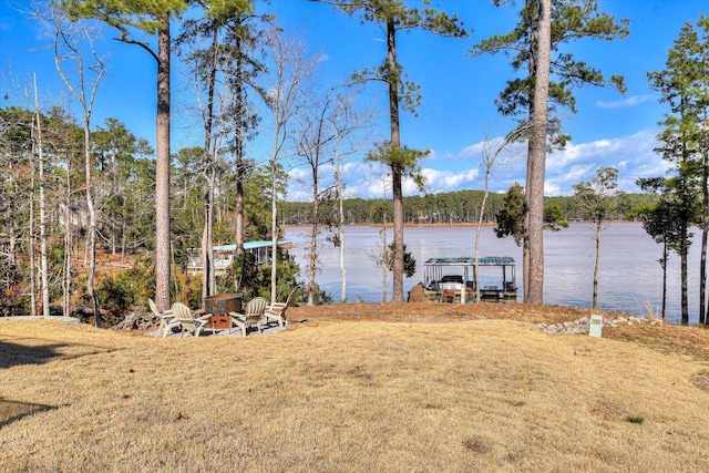 view of yard with a water view and an outdoor fire pit