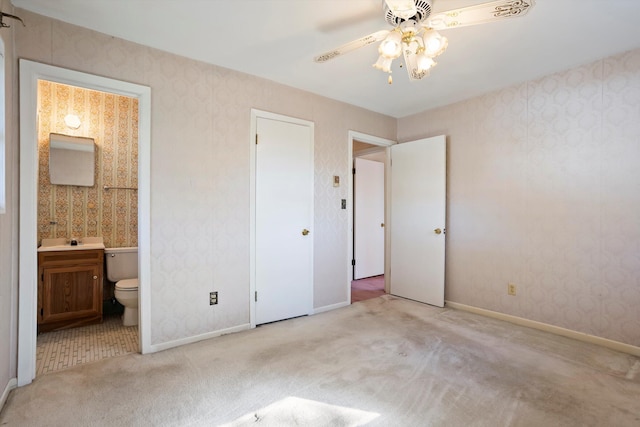 unfurnished bedroom featuring ensuite bathroom, ceiling fan, and light carpet