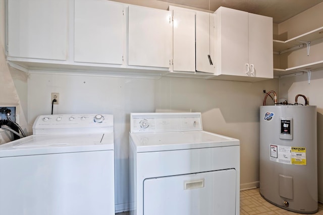 clothes washing area featuring washing machine and clothes dryer, electric water heater, and cabinets