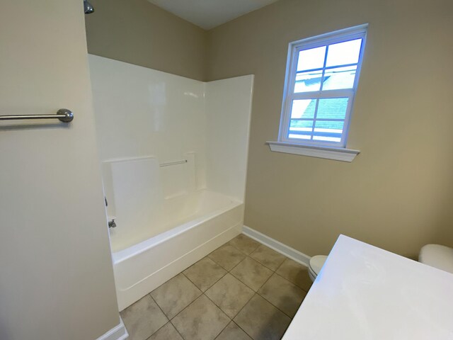 bathroom with toilet, tile patterned floors, and tub / shower combination