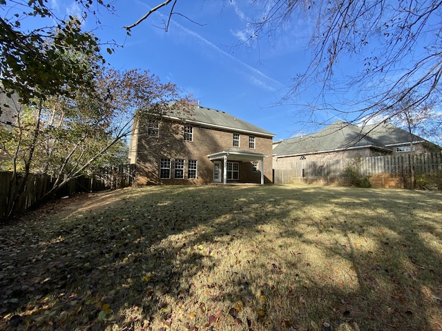 rear view of house featuring a lawn