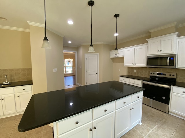 kitchen featuring hanging light fixtures, sink, appliances with stainless steel finishes, a kitchen island, and white cabinetry