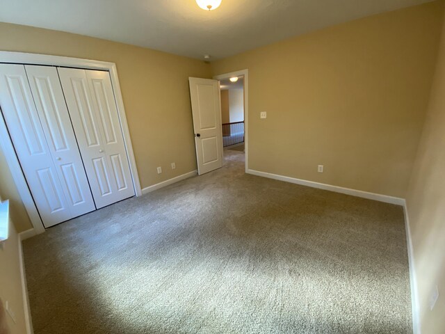 unfurnished bedroom featuring carpet and a closet