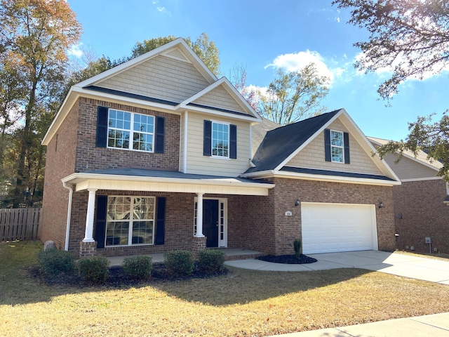 view of front of house featuring a front lawn, covered porch, and a garage