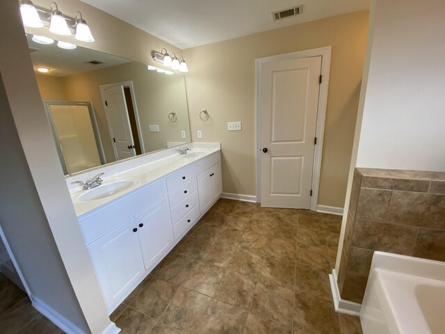 bathroom with a tub and vanity