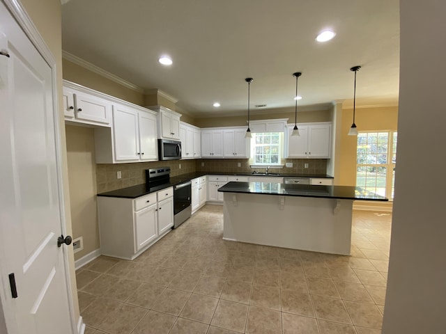 kitchen with white cabinetry, a center island, hanging light fixtures, and appliances with stainless steel finishes