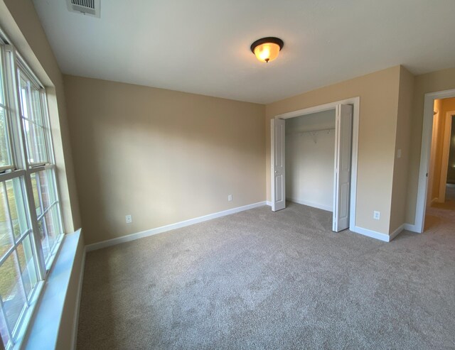 unfurnished bedroom with a closet and carpet floors