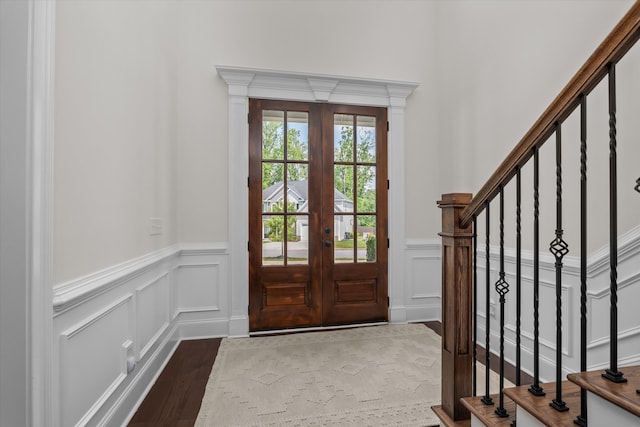 529 River Oaks Ln, Evans, GA 30809 - entryway with wood finished floors, a decorative wall, stairs, a wainscoted wall, and french doors