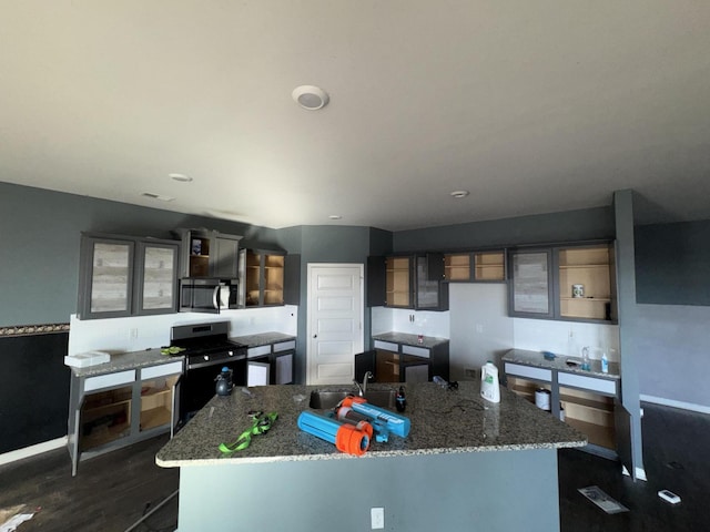 kitchen with light stone countertops, stainless steel appliances, dark hardwood / wood-style floors, and sink