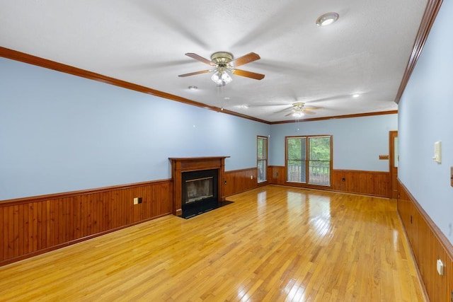 1116 Wrights Mill Rd, Aiken, SC 29801 - unfurnished living room featuring a wainscoted wall, light wood-type flooring, wood walls, a ceiling fan, and a fireplace with flush hearth