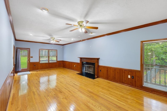 1116 Wrights Mill Rd, Aiken, SC 29801 - unfurnished living room featuring wainscoting, light wood-style flooring, ceiling fan, a textured ceiling, and a fireplace with flush hearth