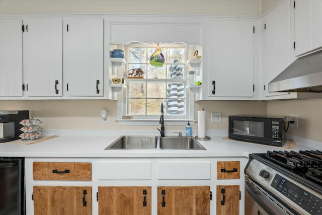 kitchen featuring stainless steel range with gas cooktop, white cabinetry, and sink