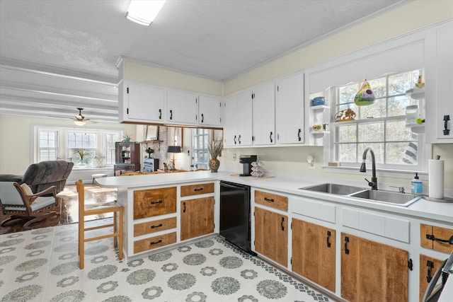 kitchen with sink, black dishwasher, kitchen peninsula, a textured ceiling, and white cabinets