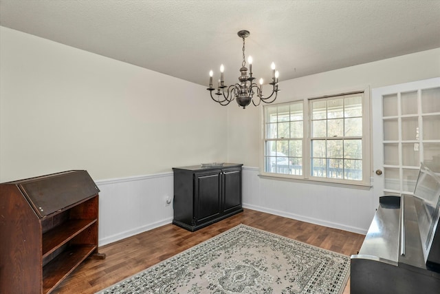 miscellaneous room with dark hardwood / wood-style flooring, a chandelier, and a textured ceiling