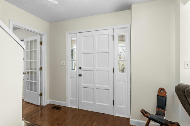 entrance foyer featuring a textured ceiling and dark wood-type flooring