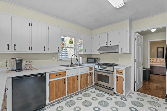 kitchen featuring white cabinetry, sink, stainless steel appliances, a textured ceiling, and ornamental molding