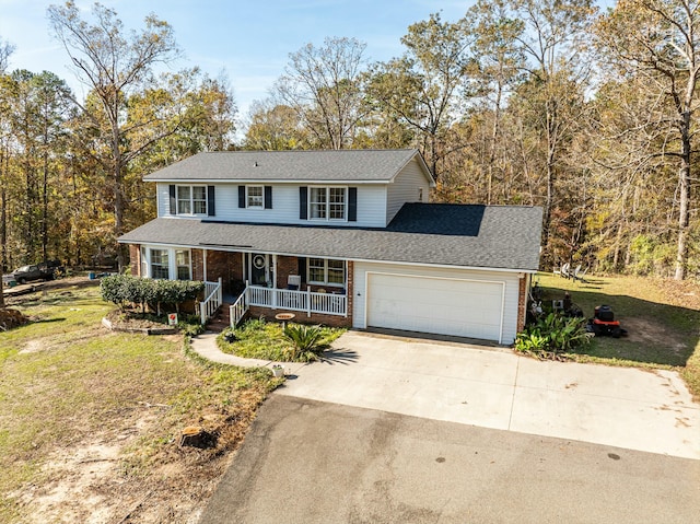 view of front of house with a porch, a garage, and a front lawn