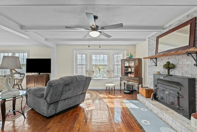 living room with a wood stove, a wealth of natural light, wood-type flooring, and a textured ceiling