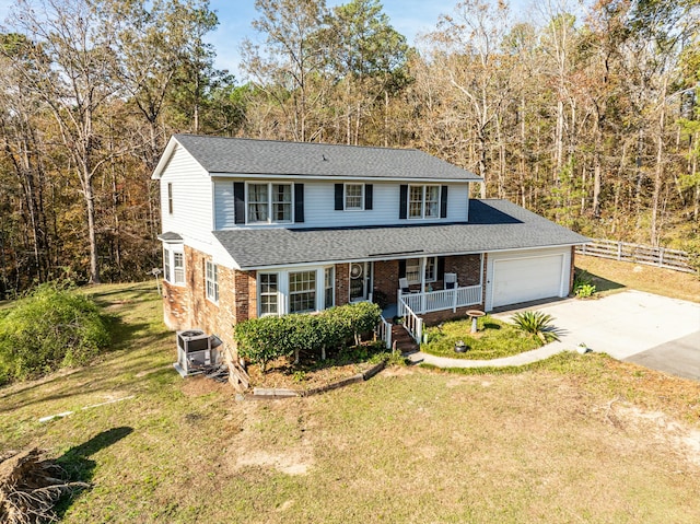 view of front property with central AC, a porch, a front yard, and a garage