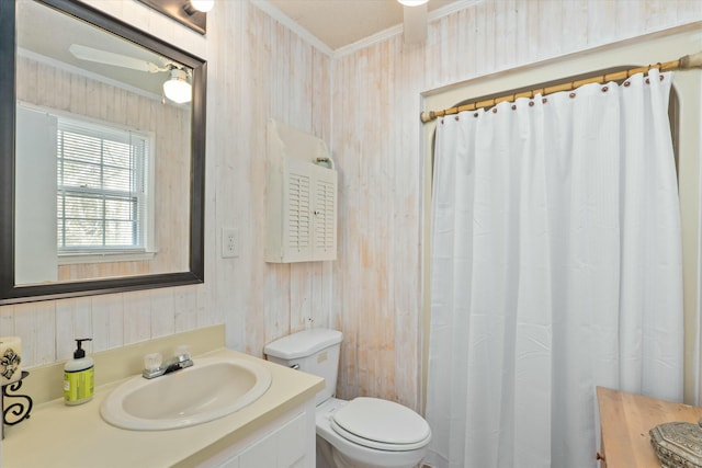 bathroom featuring a shower with curtain, vanity, wooden walls, crown molding, and toilet