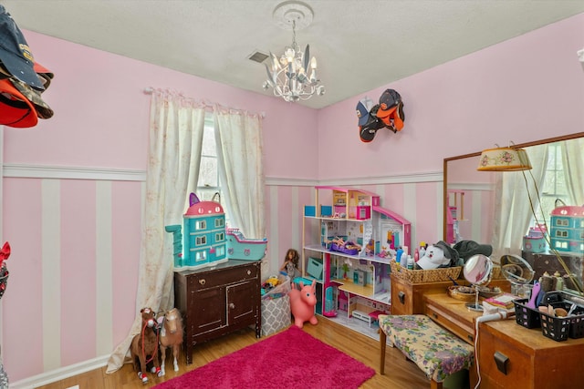 recreation room featuring a chandelier and light wood-type flooring