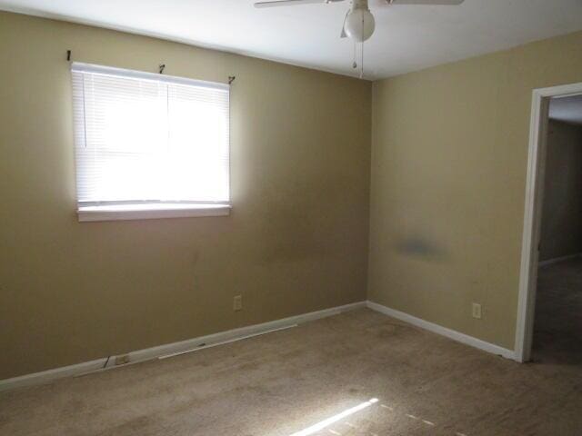 unfurnished room with light colored carpet and ceiling fan