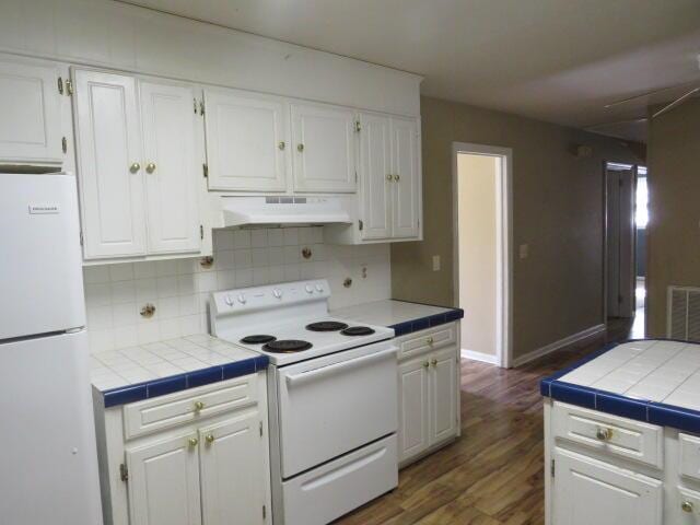 kitchen featuring white cabinetry, white appliances, and tile counters