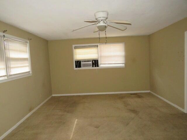 carpeted spare room with cooling unit and ceiling fan