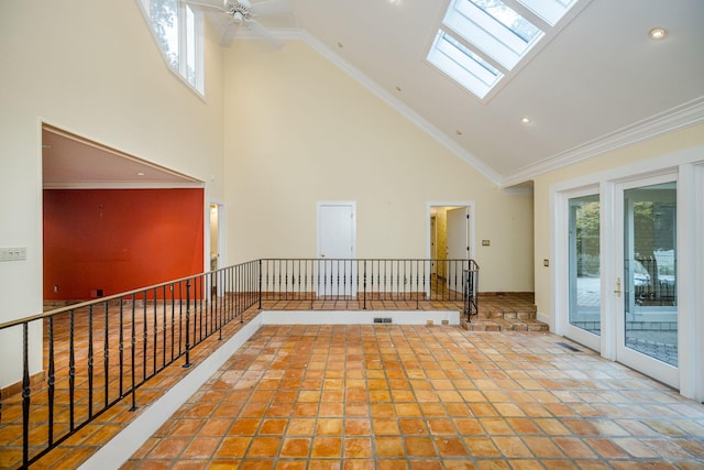 spare room featuring a skylight, ceiling fan, high vaulted ceiling, and ornamental molding