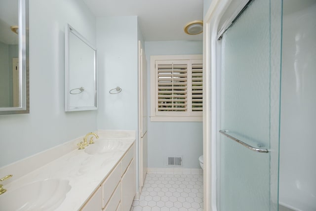 bathroom with vanity, toilet, and a shower with shower door