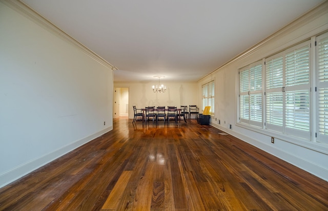 unfurnished dining area featuring dark hardwood / wood-style floors, crown molding, and an inviting chandelier