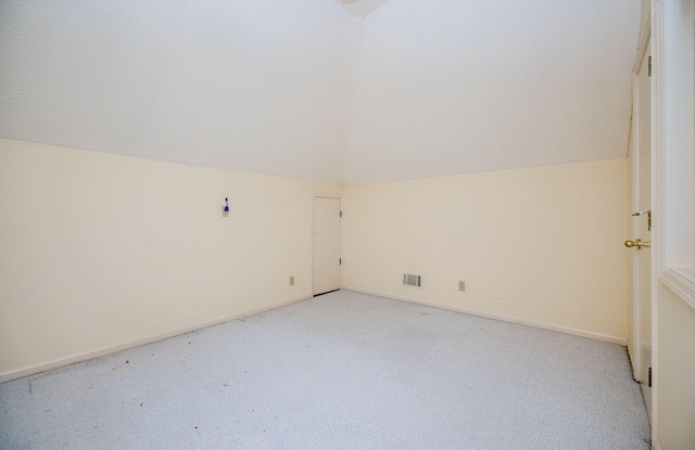 additional living space with vaulted ceiling with skylight, ceiling fan, light carpet, and a textured ceiling