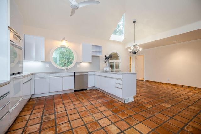 kitchen featuring kitchen peninsula, tasteful backsplash, stainless steel dishwasher, ceiling fan with notable chandelier, and white cabinetry