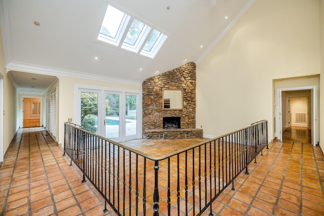 hallway with ornamental molding and high vaulted ceiling