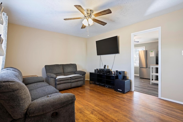 living room with wood-type flooring, a textured ceiling, and ceiling fan