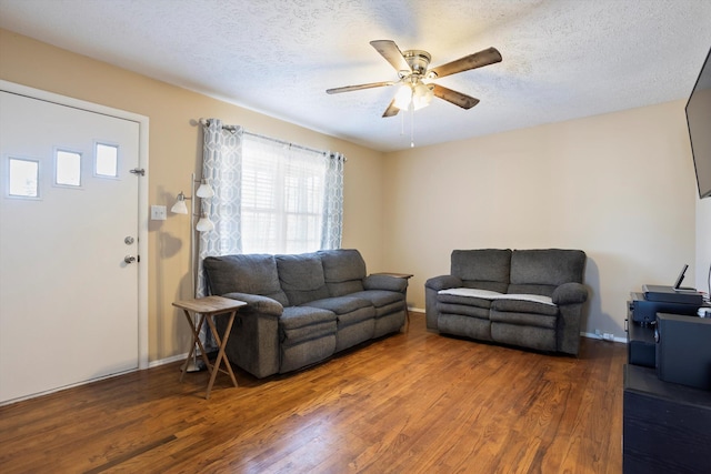 living room with ceiling fan, a textured ceiling, and dark hardwood / wood-style flooring