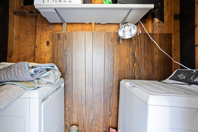 laundry room with washer and clothes dryer and wooden walls