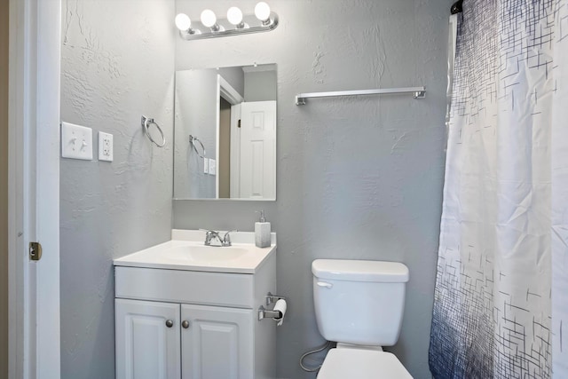 bathroom with a shower with curtain, vanity, and toilet