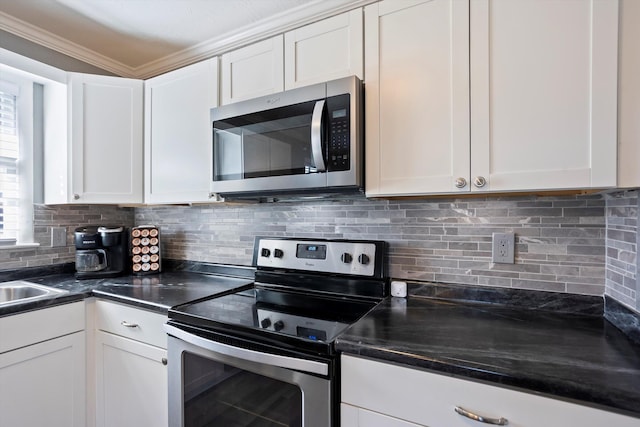 kitchen with white cabinetry, ornamental molding, stainless steel appliances, and tasteful backsplash