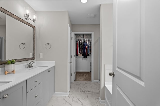 165 Myrtle Grv Trl, Evans, GA 30809 - bathroom featuring marble finish floors, double vanity, baseboards, a bathtub, and a walk in closet