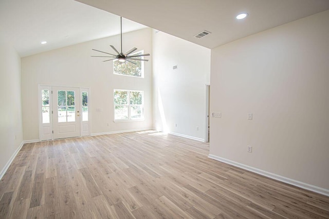 unfurnished living room with ceiling fan, light wood-type flooring, and high vaulted ceiling