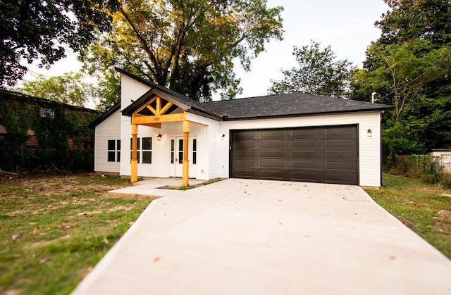 modern farmhouse style home with a front yard and a garage