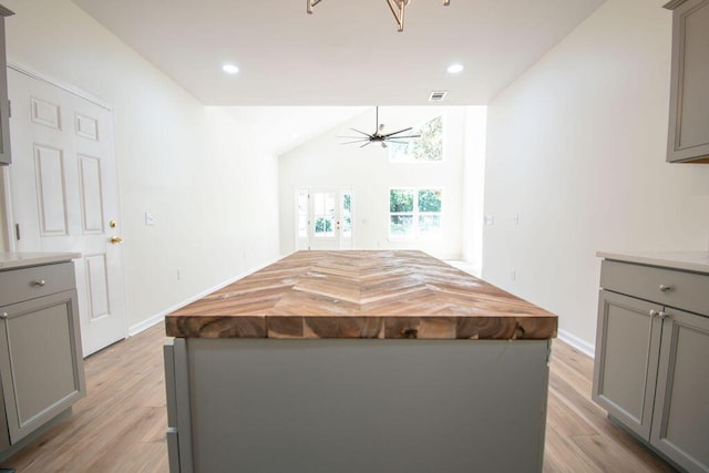 kitchen with wood counters, a center island, ceiling fan, gray cabinets, and light wood-type flooring