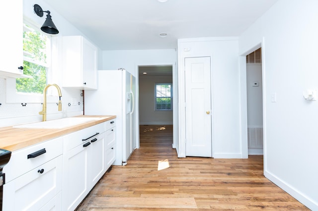 1468 Dewitt St, Augusta, GA 30901 - kitchen featuring white cabinets, backsplash, and light wood-style floors